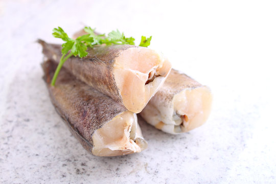raw fish hake in white packaging decorated with parsley