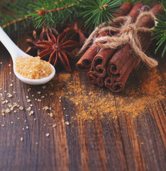Sticks and powder of cinnamon, anise, sugar cane on the wooden background. selective focus
