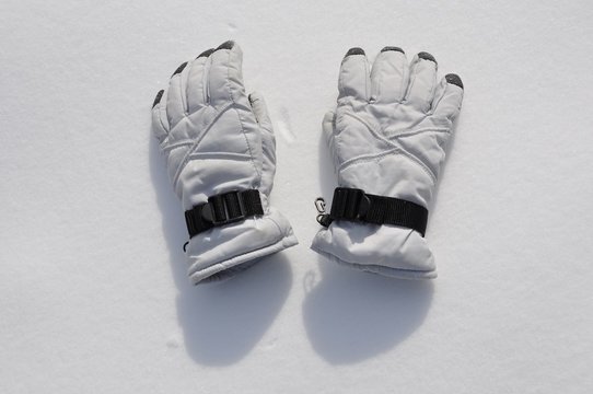 Pair of white gloves over snow