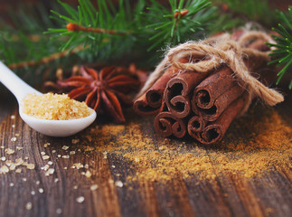 Sticks and powder of cinnamon, anise, sugar cane on the wooden background. selective focus