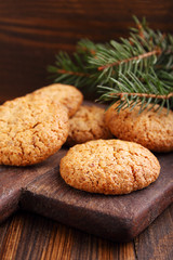 Almond cookie on a brown wooden background, the branches of spruce