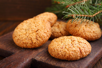 Almond cookie on a brown wooden background, the branches of spruce