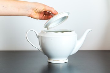 Elegant porcelain white jug and woman hand