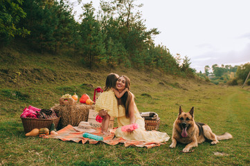mother and daughter at a picnic with a dog