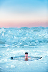 Winter swimming. Man in an ice-hole