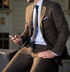 Male model in a suit with a mobile phone in his hand
