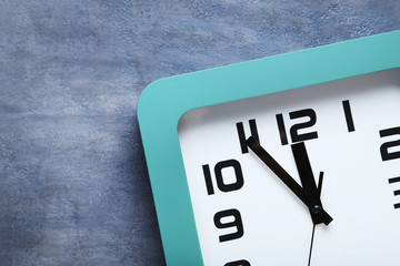 Green clock on a grey wooden table