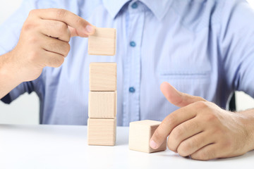 Male hand holding the wooden cube