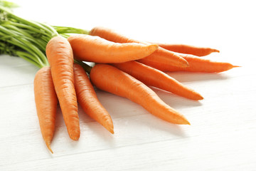 Fresh and sweet carrots on a white wooden table