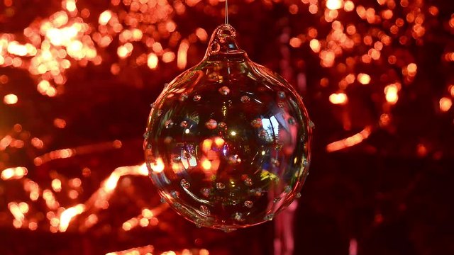 Palla di Natale in vetro, gioco di luci su sfondo rosso
