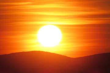 Bright orange sunset above the mountains. Quebec, Canada.