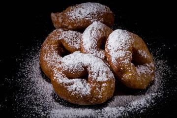 Sprinkling sugar powder on donut