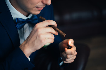 the groom in a suit smoking cigar