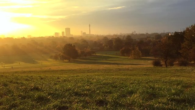 Scenic morning timelapse view of London, England from a North London park at sunrise