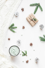 Christmas composition. Hot chocolate, christmas gift, knitted blanket, pine cones, fir branches. Flat lay, top view