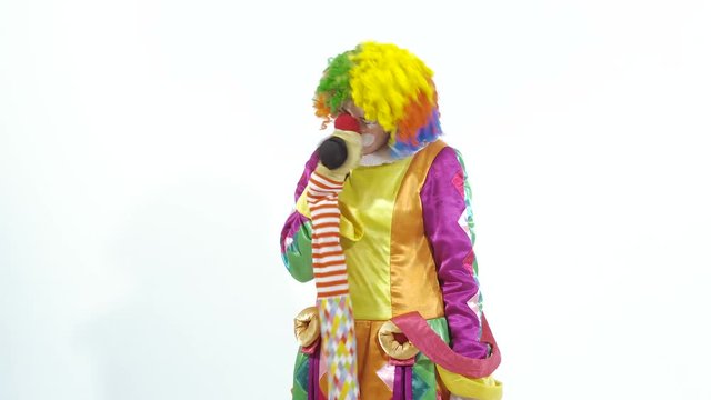 Funny young clown playing with puppet