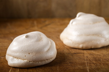 Meringues on wooden background