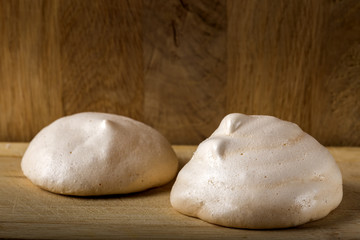 Homemade meringues on wooden background