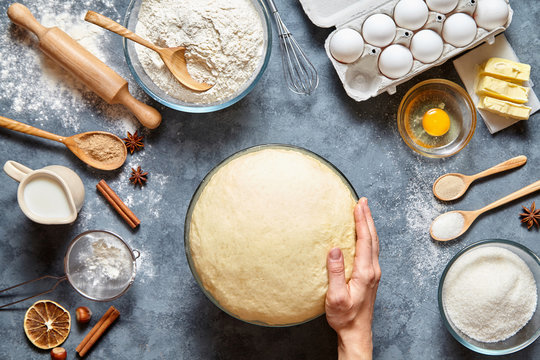 Dough preparation recipe bread, pizza or pie making ingridients, food flat lay on kitchen table background. Hands working with butter, milk, yeast, flour, eggs, sugar pastry or bakery cooking.