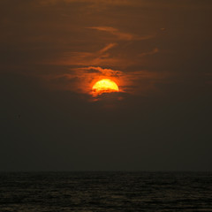 setting sun behind a cloud