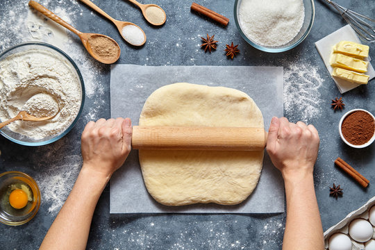 Dough Bread, Pizza Or Pie Recipe Homemade Preparation. Female Chef Cook Hands Rolling Dough With Pin. Food Ingridients Flat Lay On Kitchen Table. Working With Pastry Or Bakery Cooking. Top View