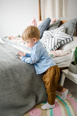Young cute baby boy with smartphone in christmas decorated room