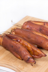 Smoked pork hooves on the wooden board