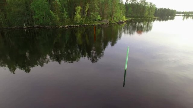 Green and red lateral seamarks at a lake, aerial orbit shot