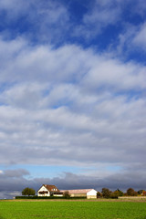 Obraz premium Duży dom na wsi z wiosną zielony krajobraz