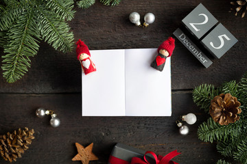 Christmas postcard with christmas decoration, wooden calendar and empty white notebook. Christmas concept. Overhead view.