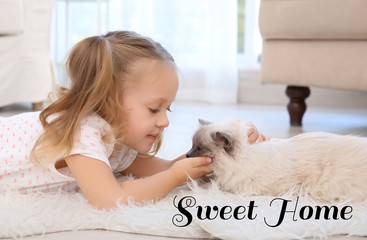 Cute little girl with cat on floor. Text SWEET HOME.