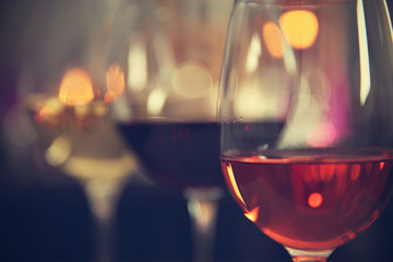 Three glasses with tasty wine on bright background, closeup