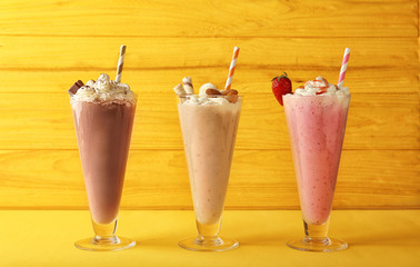 Delicious milkshakes on wooden background