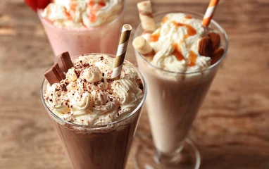 Foto auf Acrylglas Milchshake Delicious milkshakes on wooden background