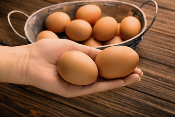 Female hand holding raw eggs, closeup