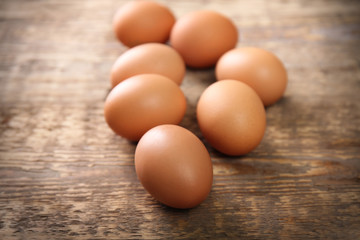 Raw eggs on wooden background