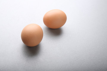 Raw eggs on grey background