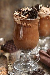Two portions of hot chocolate with wipped cream and cookies.