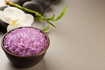 Spa stones, sea salt and orchid flower on color background