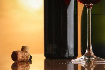 Wine bottles with barrel and corks on desk