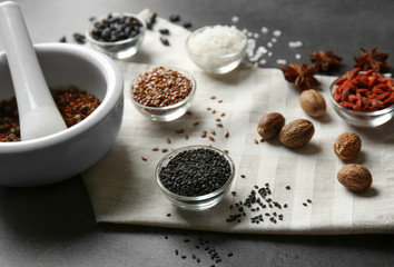 Composition with different spices and mortar on gray background