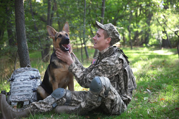 Soldier with german shepherd dog in forest