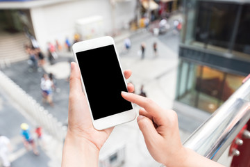 Hand touching blank screen mobile smart phone with city street outdoor in background