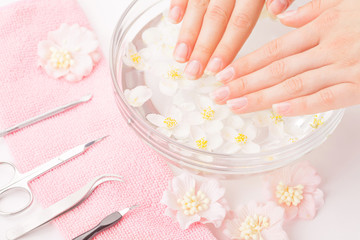 Beautiful woman's hands with manicure in bowl of water