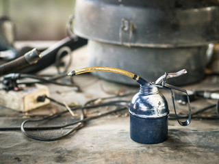 Oil can on wooden table in the garage.