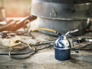 Oil can on wooden table in the garage.