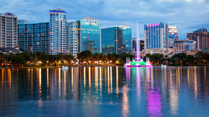 Orlando, Florida City Skyline on Lake Eola as Night Falls (logos blurred for commercial use) - obrazy, fototapety, plakaty