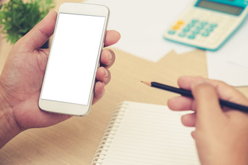 Businessman's hands holding and use mobile phone on on office table