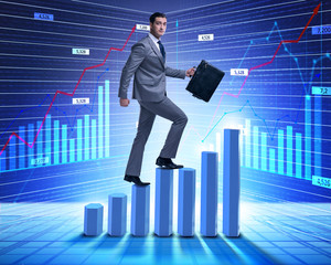 Businessman climbing bar charts in business concept