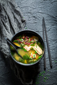 Yummy miso soup with salmon in black bowl